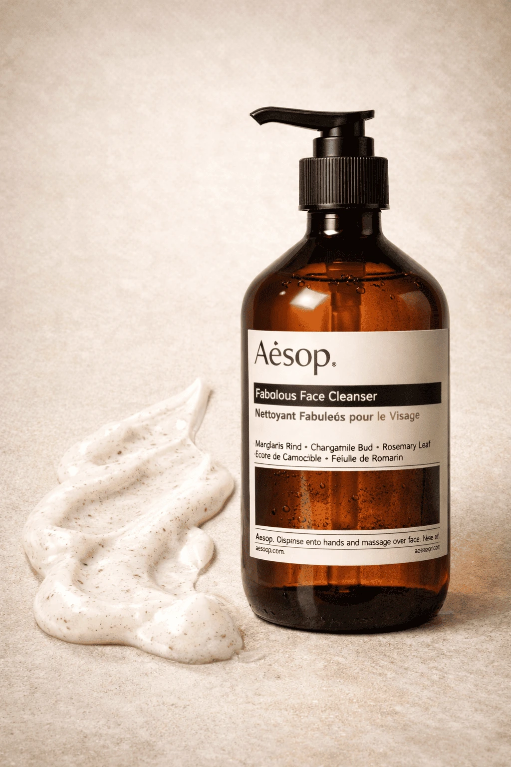 Aesop face wash amber bottle with pump dispenser shown alongside cleanser texture